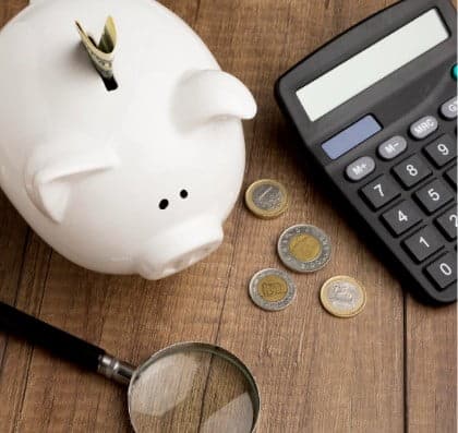 Piggy bank beside calculator — Top BPO Solutions | Outsourcing Services In The Philippines