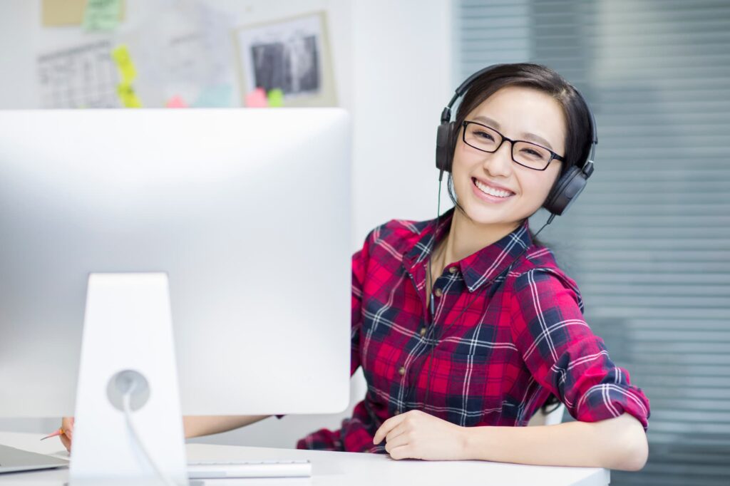Asian lady smiling while working — Top BPO Solutions | Outsourcing Services In The Philippines