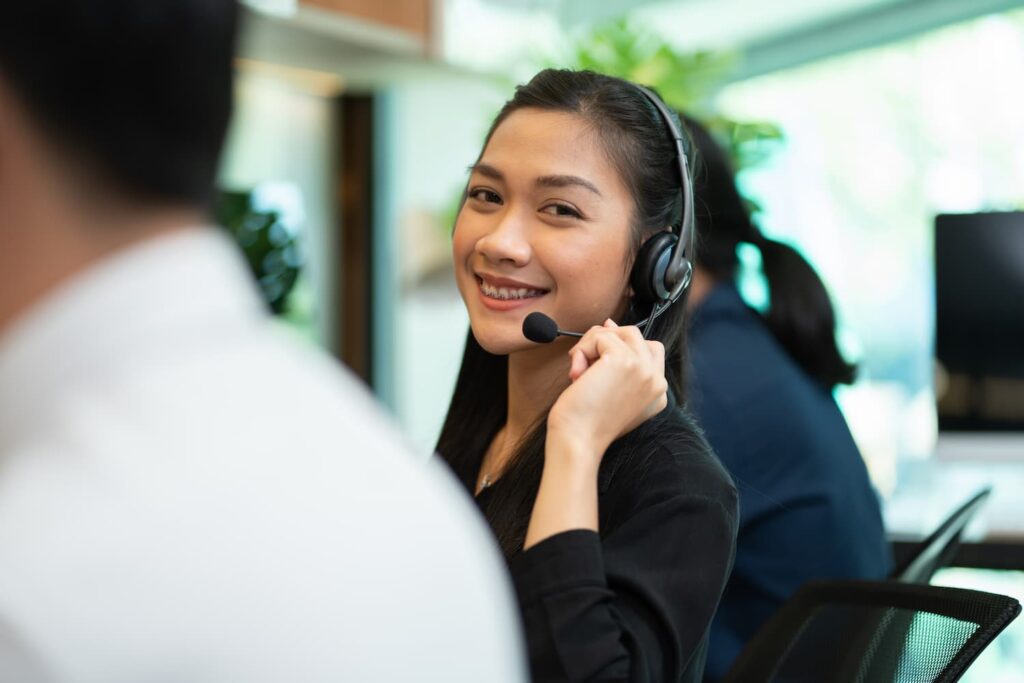 Asian female telemarketing agent wearing microphone — Business process outsourcing & offshore staffing | Sourcefit