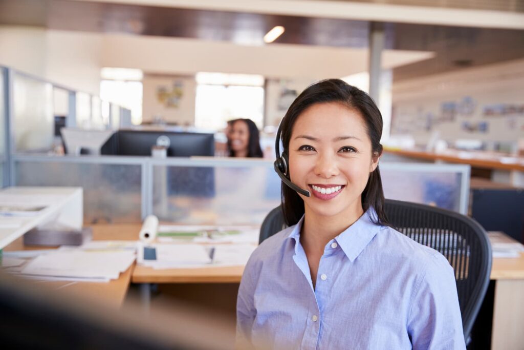 Young asian woman working in a call center — Business process outsourcing & offshore staffing | Sourcefit