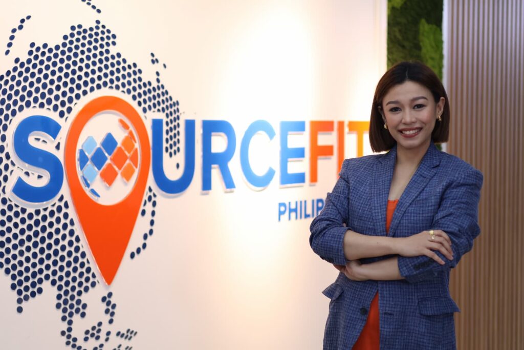 Sourcefit staff standing in front of the Sourcefit back draft — Business process outsourcing & offshore staffing | Sourcefit