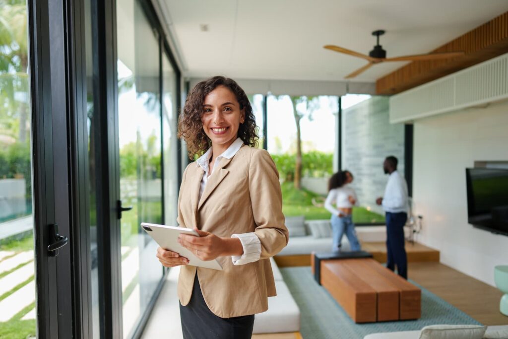 Real estate staff wearing brown coat smiling — Business process outsourcing & offshore staffing | Sourcefit