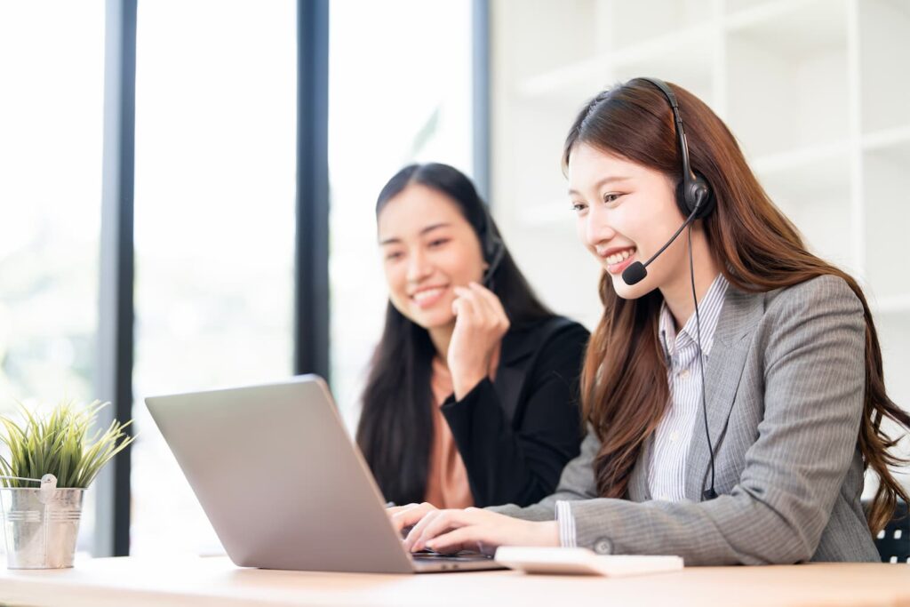Two ladies wearing headset at work — Business process outsourcing & offshore staffing | Sourcefit