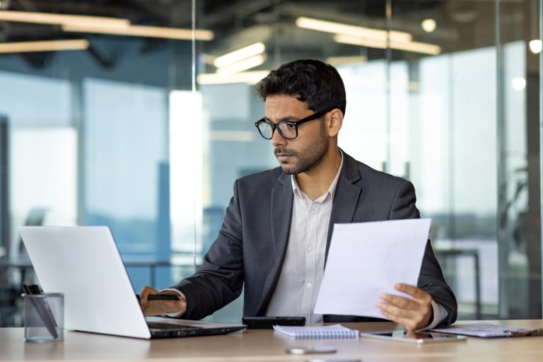 Research analyst reviewing data on laptop: Offshore Staffing & BPO Across 6 Countries