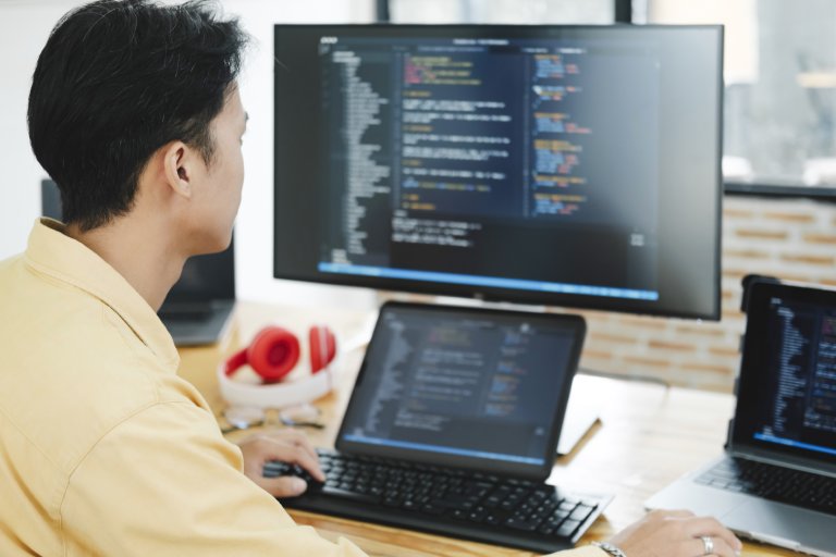Software developer reviewing code: Offshore Staffing & BPO Across 6 Countries