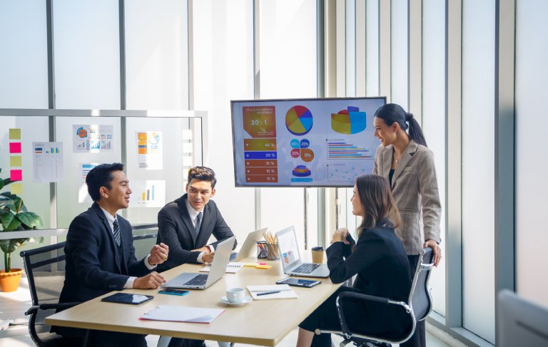 Sales team reviewing business development charts: Offshore Staffing & BPO Across 6 Countries