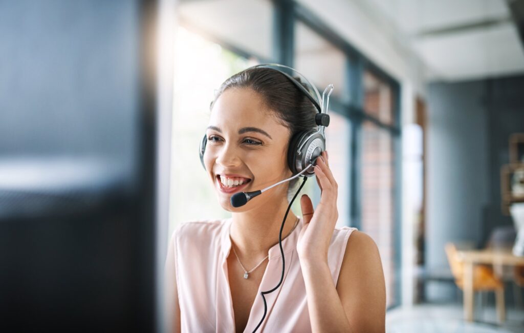 Support agent smiling on headset call: Offshore Staffing & BPO Across 6 Countries