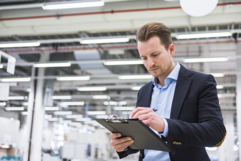 Man reviewing checklist on factory floor: Offshore Staffing & BPO Across 6 Countries
