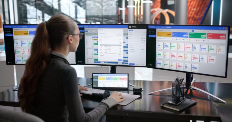 Woman managing bookings on multiple screens: Offshore Staffing & BPO Across 6 Countries